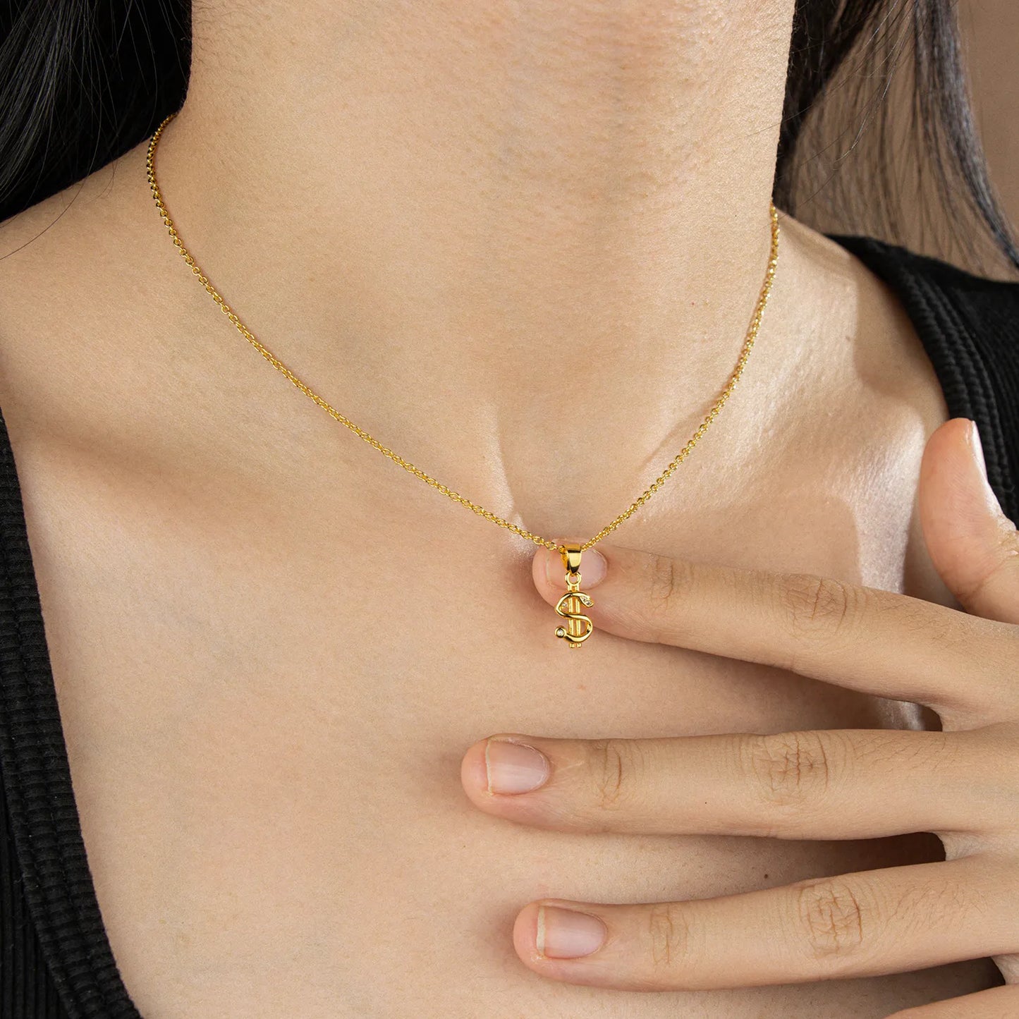 Trendy gold dollar sign pendant necklace with subtle sparkles, a stylish accessory for everyday wear and party occasions