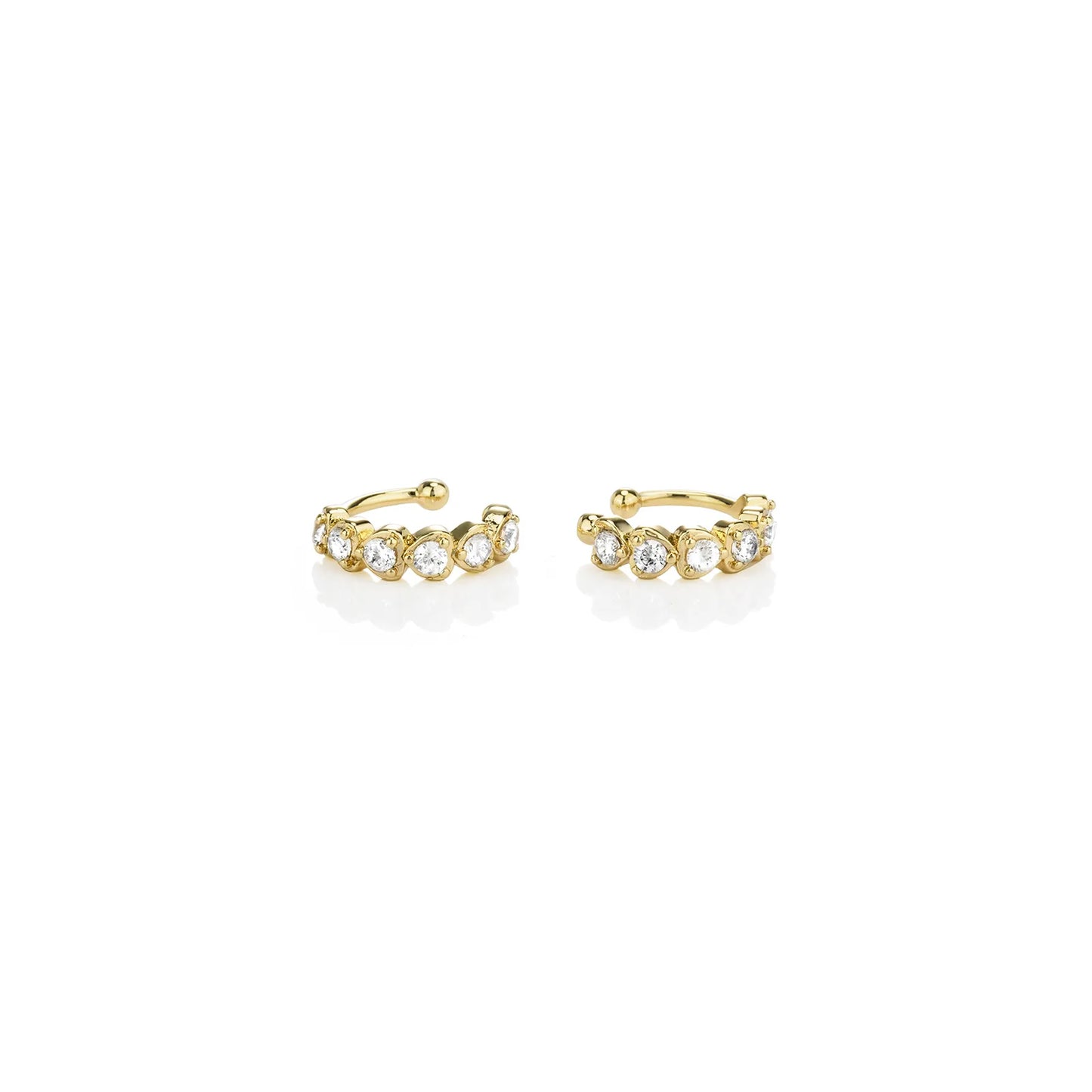 Pair of gold toned ear cuffs with cubic zirconia stones, showcasing a stylish and delicate design