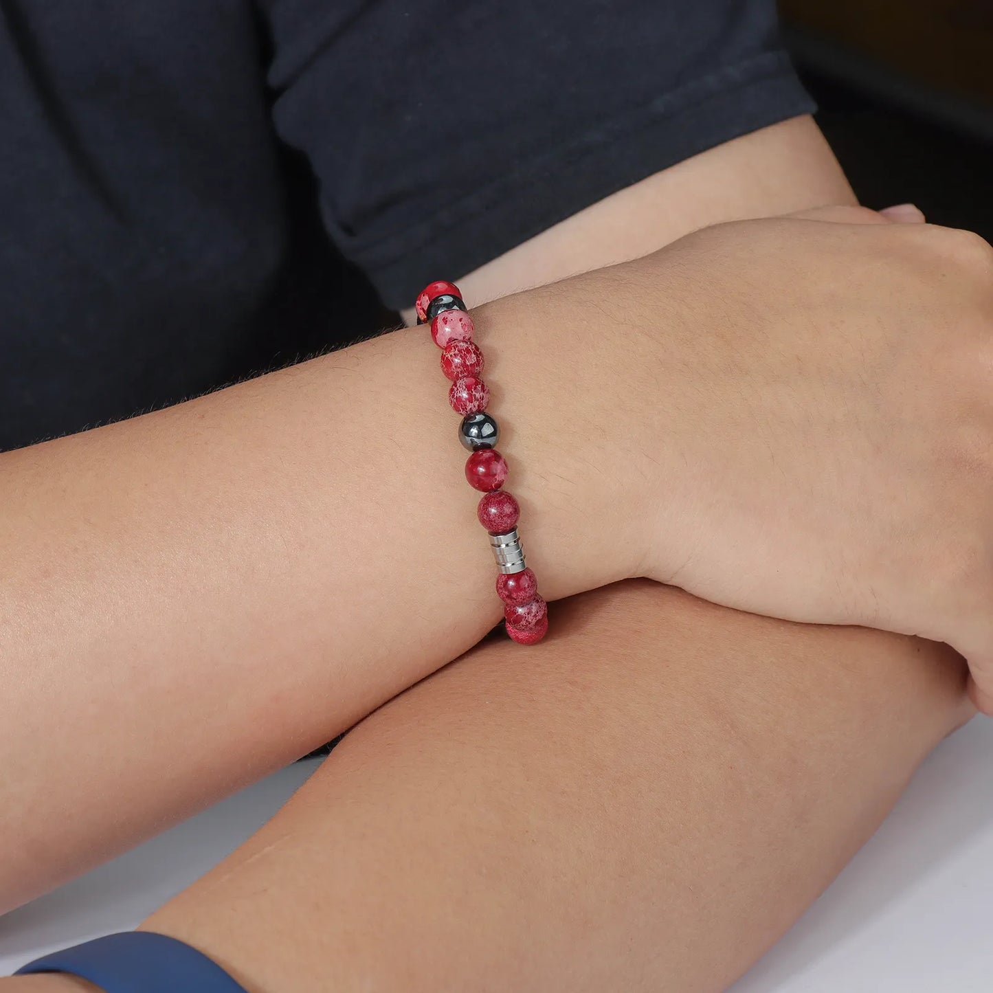 Bead bracelet with red and black stones, stainless steel clasp, fashionable accessory.