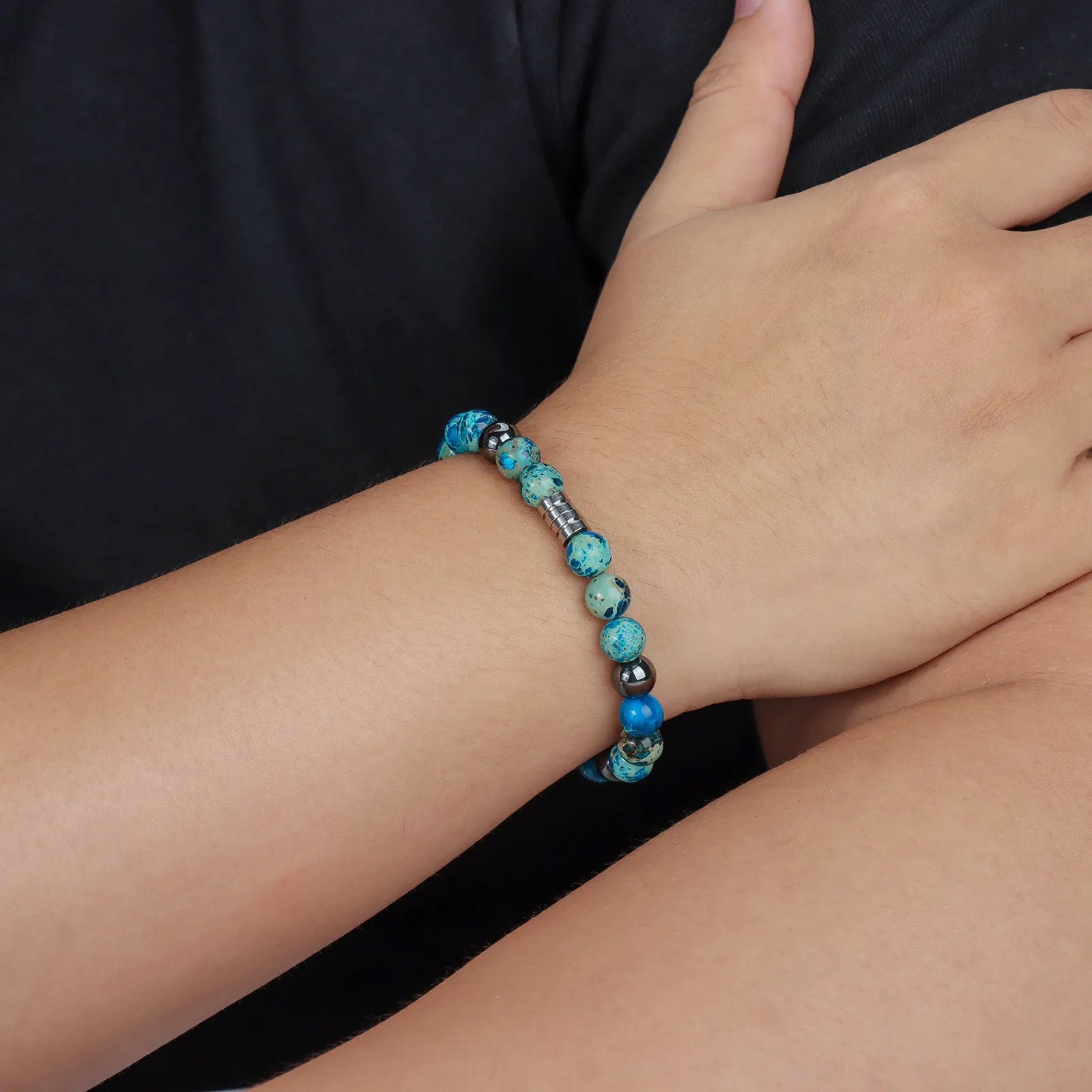 Beaded bracelet with blue stones, black beads and stainless steel clasp.