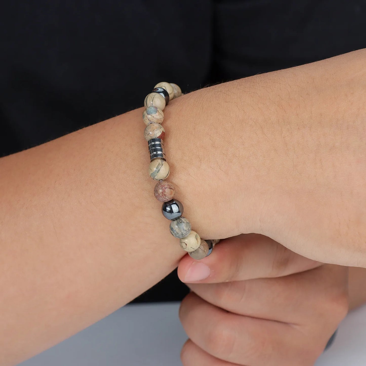 Beaded bracelet with mixed - color stones and stainless - steel detail, showcasing stylish design for men and women.
