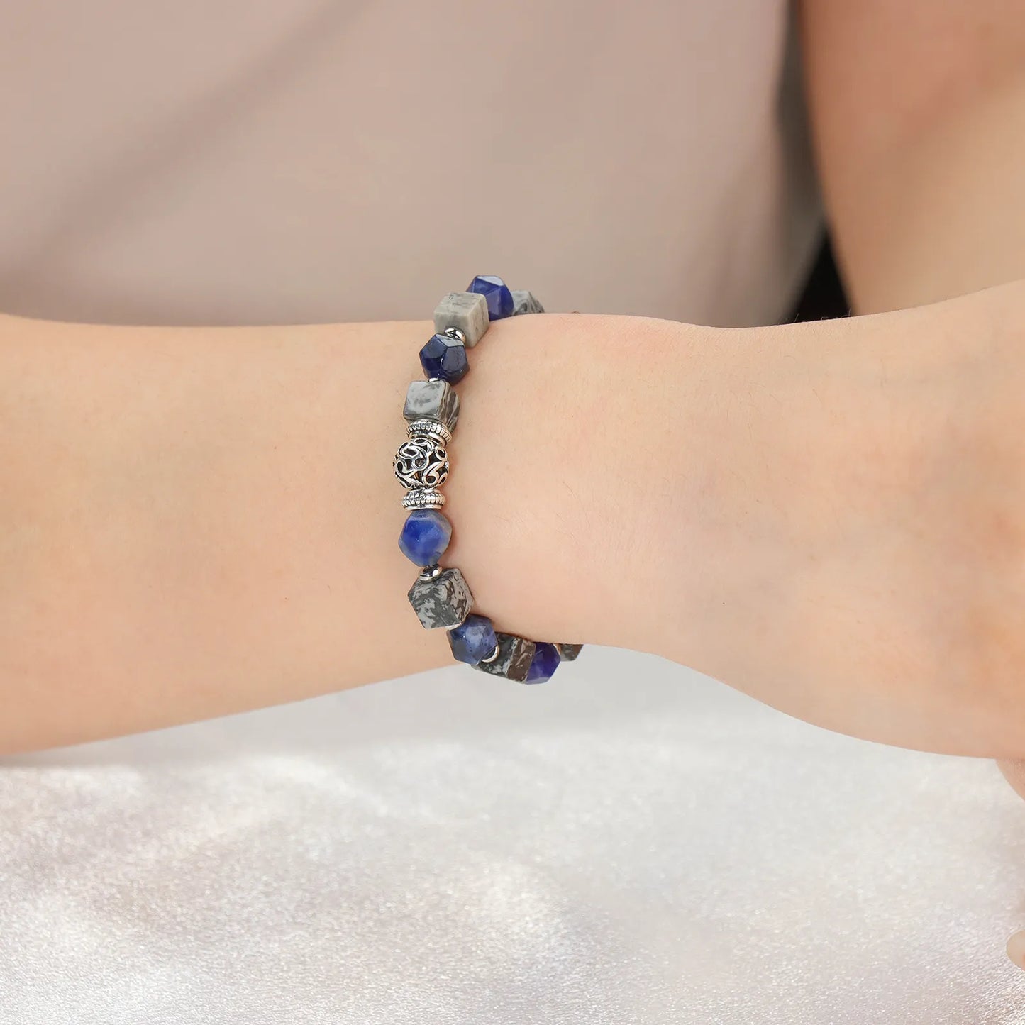 Blue gray stone beaded bracelet with intricately designed silver accents.