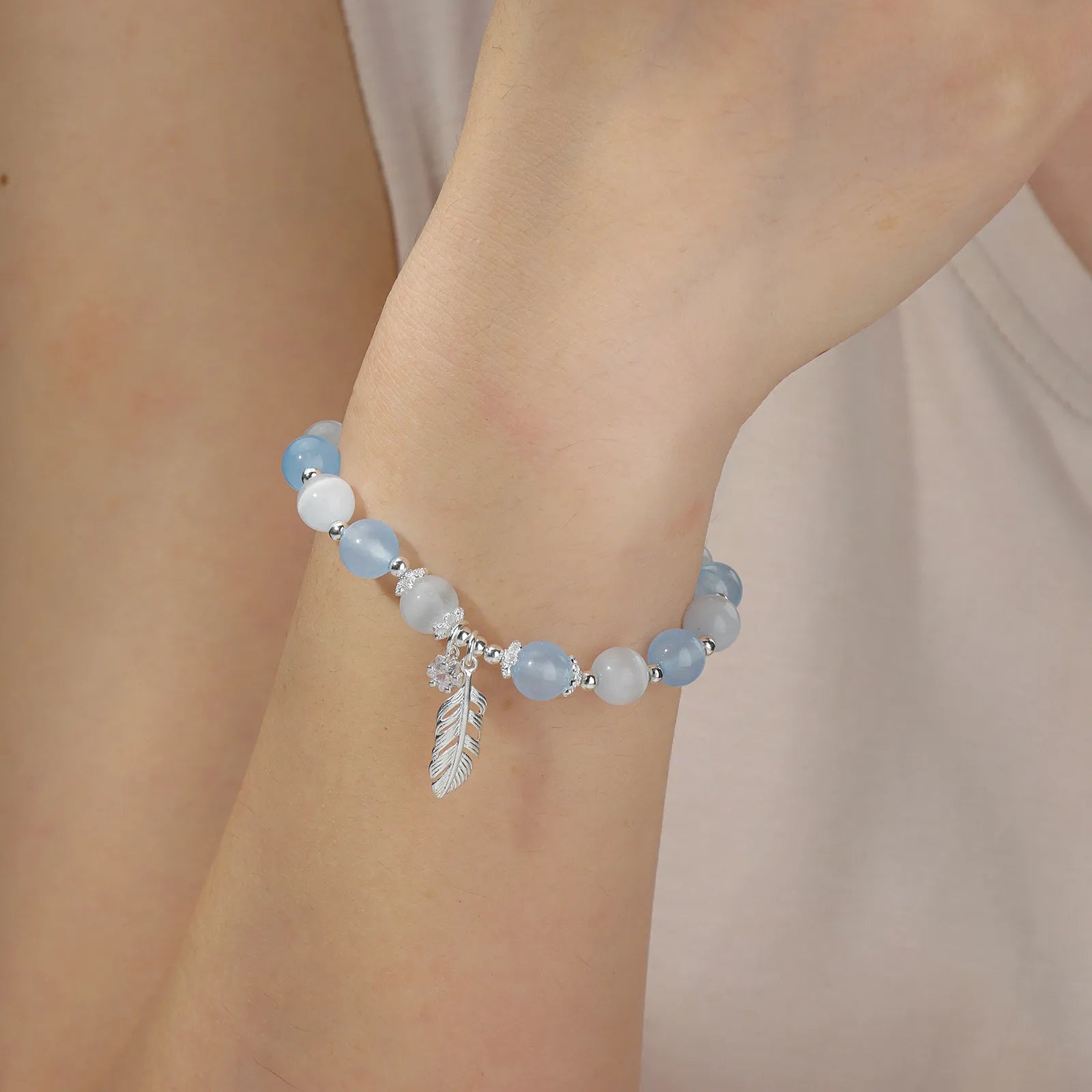 Beaded bracelet with blue and white stones and star feather charm.