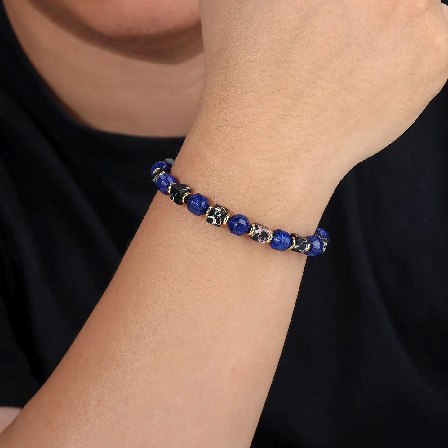 Stylish bracelet made of blue and black stone beads with gold - toned accents.
