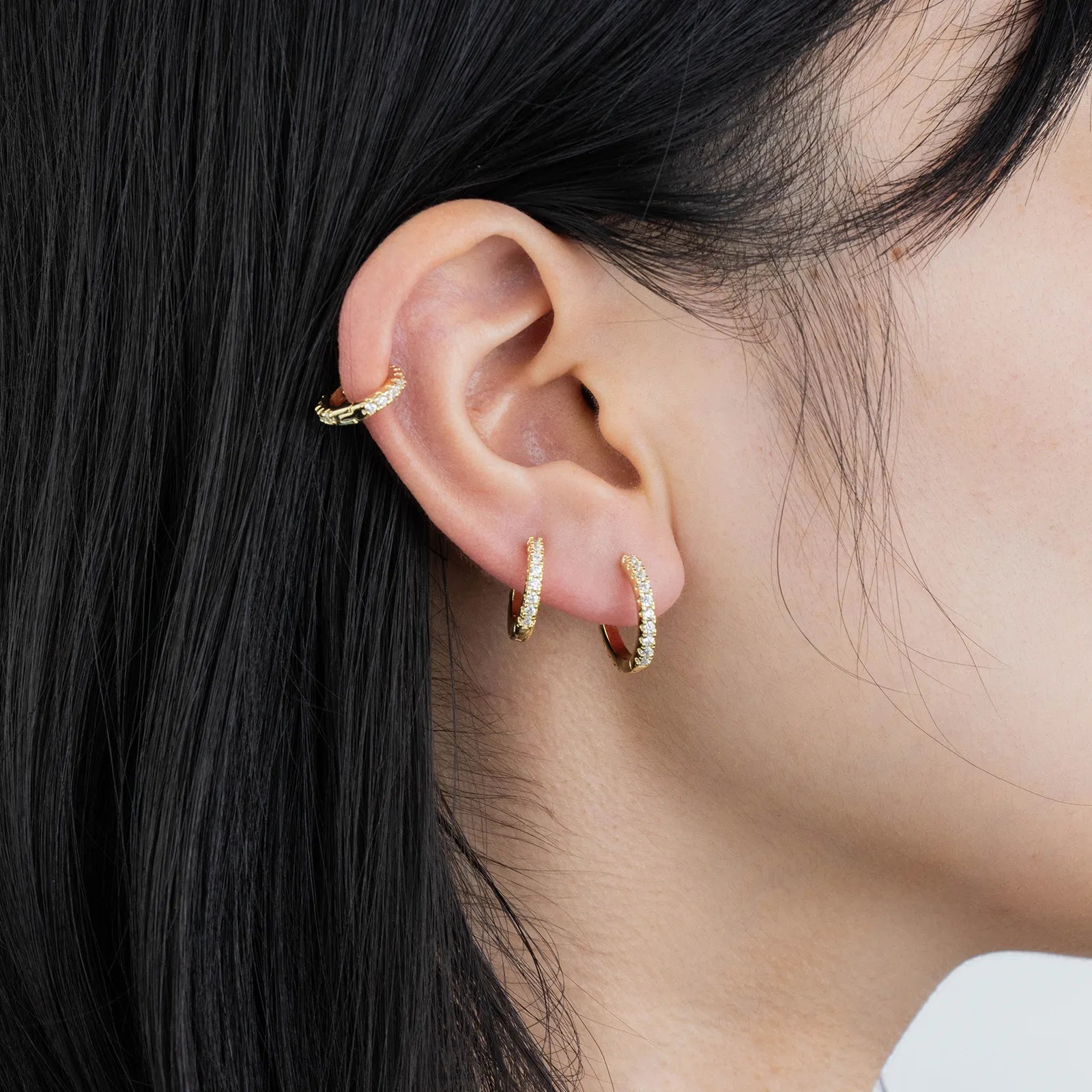 Ajatine chic gold hoop earrings with sparkling cubic zirconia stones, showcasing a delicate and stylish design for daily wear, catching light beautifully