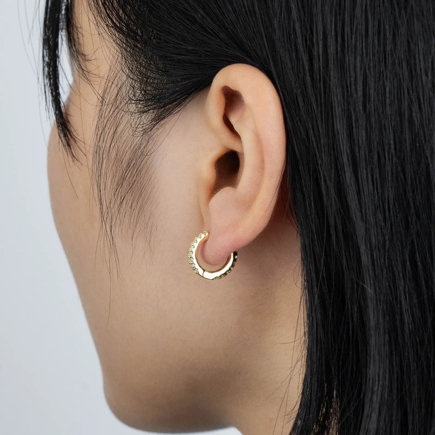 Ajatine chic gold hoop earrings with sparkling cubic zirconia stones, showcasing a delicate and stylish design for daily wear, catching light beautifully