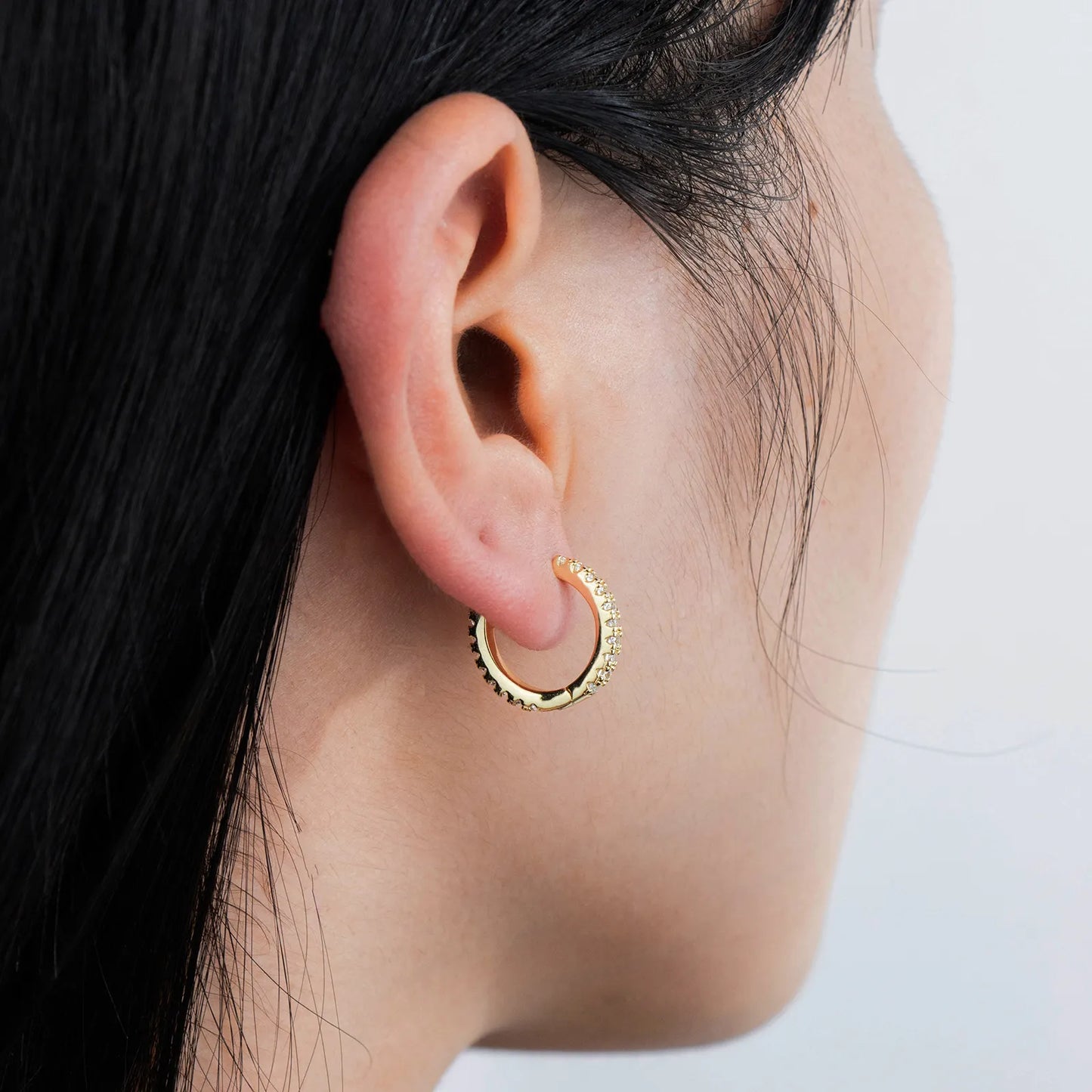 Ajatine chic gold hoop earrings with sparkling cubic zirconia stones, showcasing a delicate and stylish design for daily wear, catching light beautifully