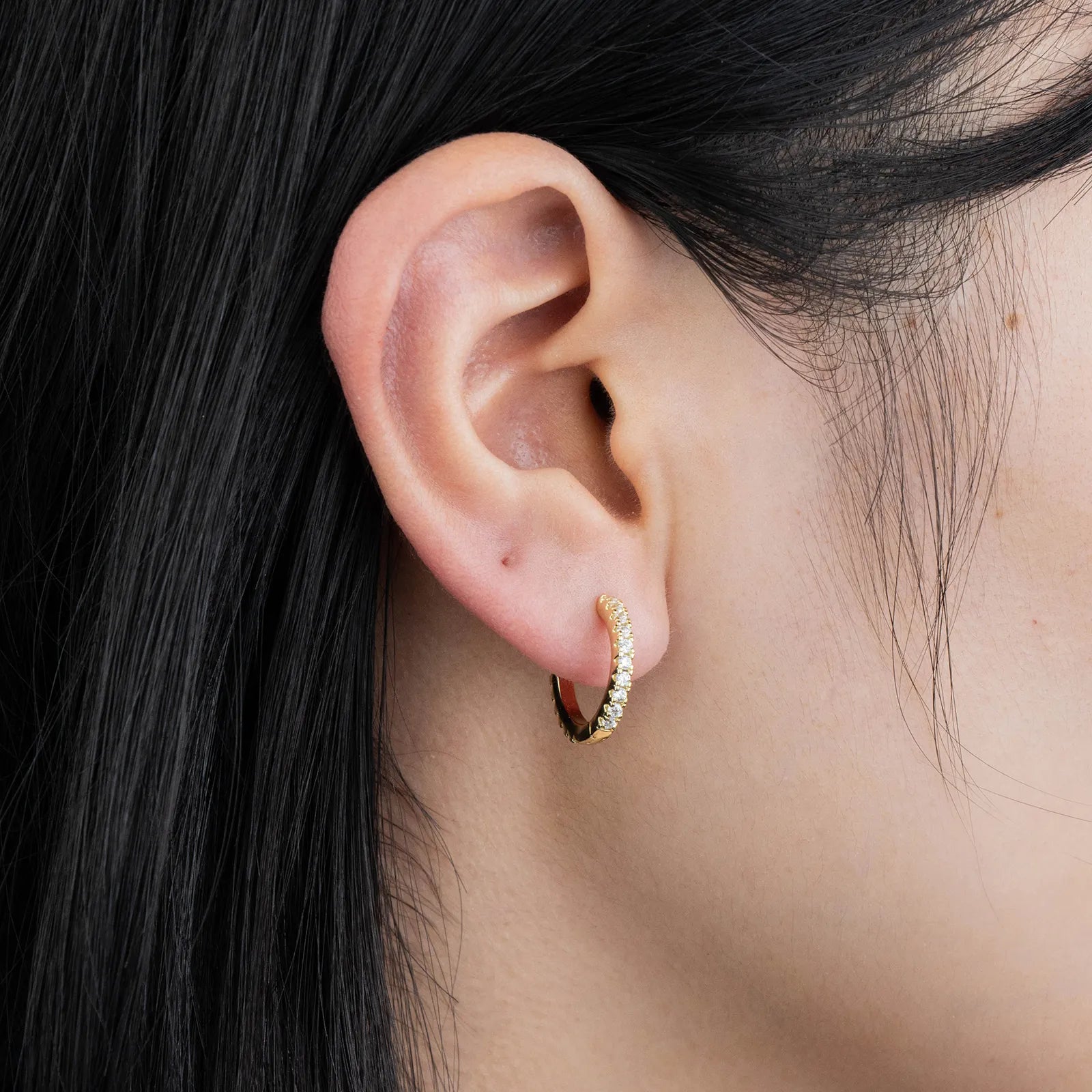 Ajatine chic gold hoop earrings with sparkling cubic zirconia stones, showcasing a delicate and stylish design for daily wear, catching light beautifully