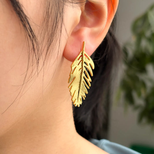 Ajatine gold feather earrings are perfect for adding elegance to a woman's fashionable outfit.