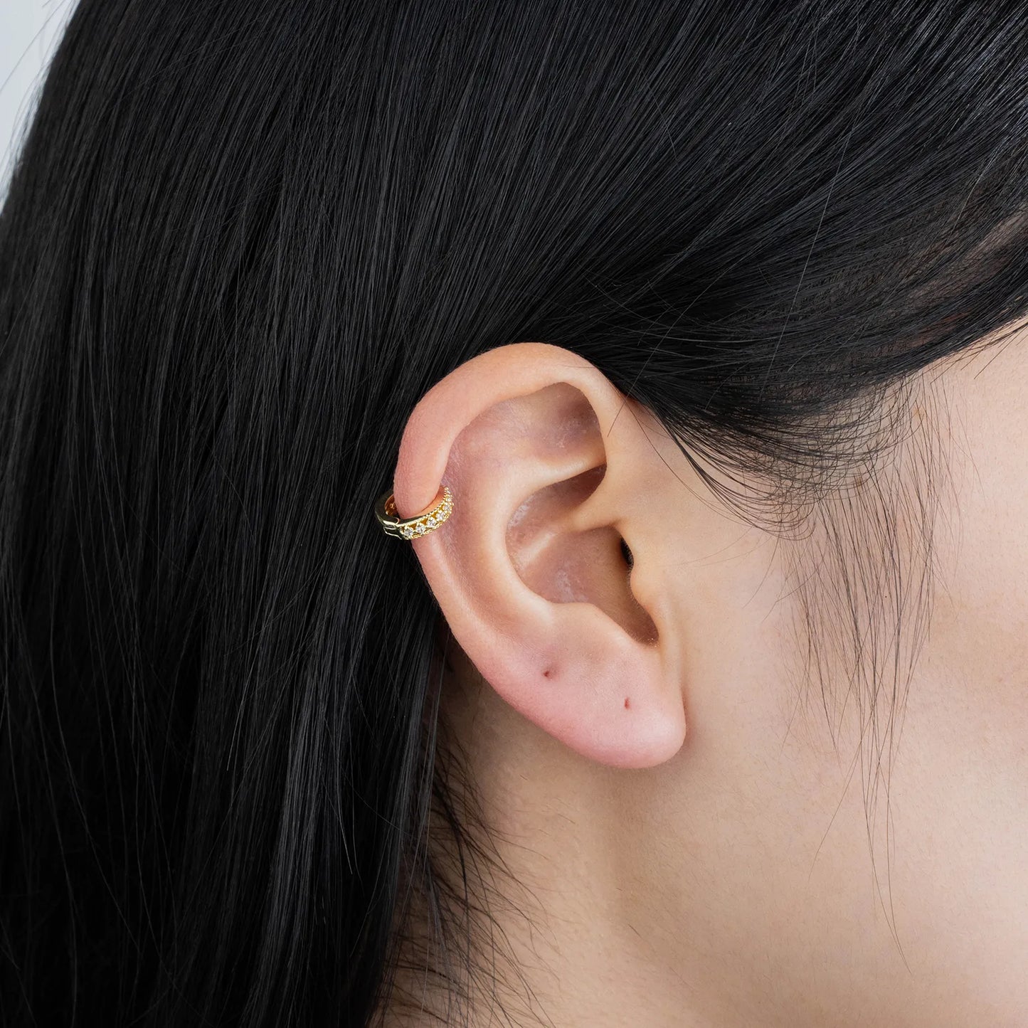 Ajatine gold huggie earrings with zircon stones, showcasing classic elegant design for daily wear