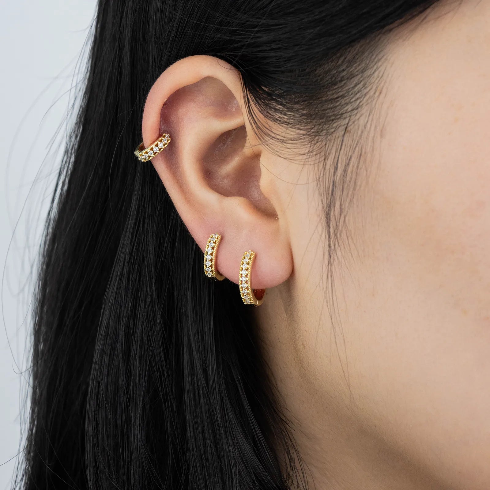 Ajatine gold huggie earrings with zircon stones, showcasing classic elegant design for daily wear
