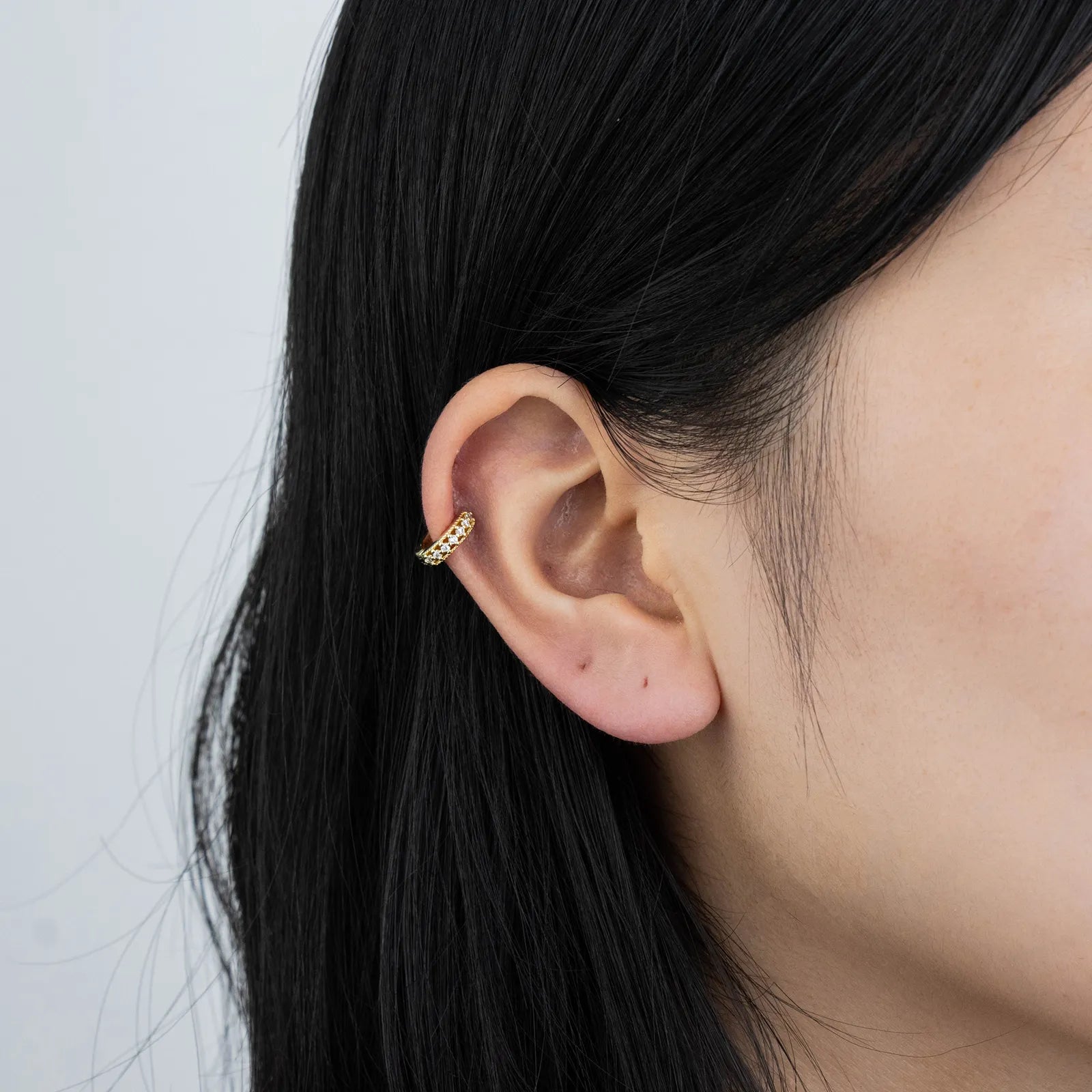 Ajatine gold huggie earrings with zircon stones, showcasing classic elegant design for daily wear