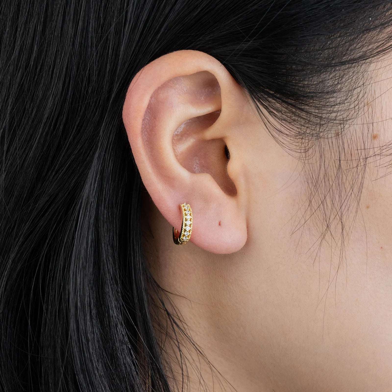 Ajatine gold huggie earrings with zircon stones, showcasing classic elegant design for daily wear