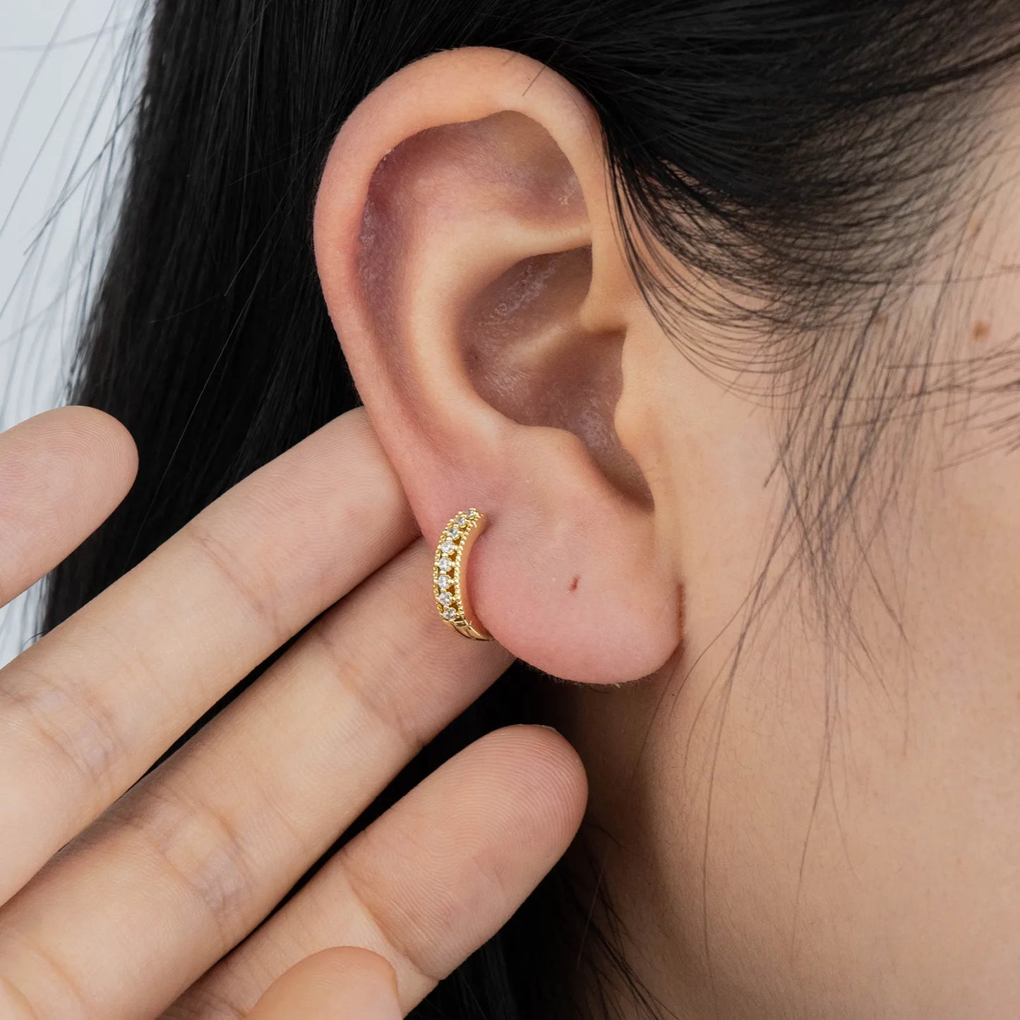 Ajatine gold huggie earrings with zircon stones, showcasing classic elegant design for daily wear