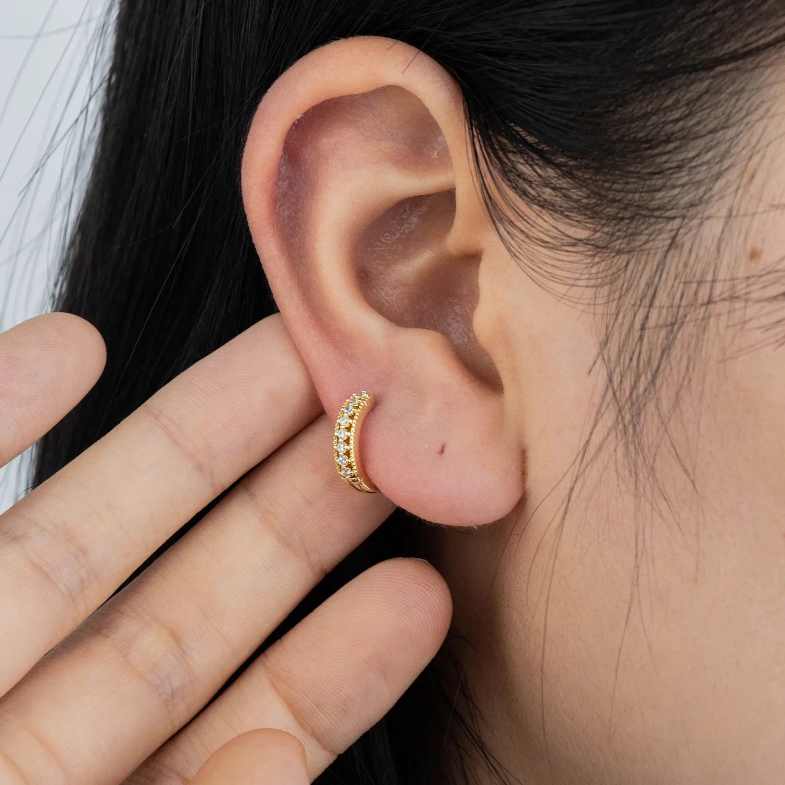 Ajatine gold huggie earrings with zircon stones, showcasing classic elegant design for daily wear