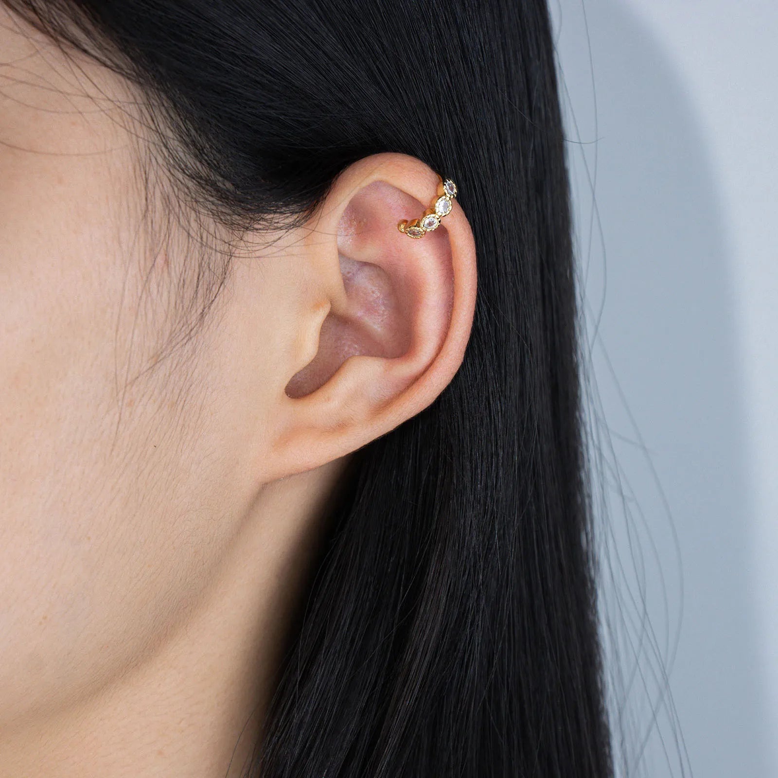 Ajatine gold ear cuffs adorned with zircon stones, perfect for stylish ear jewelry looks