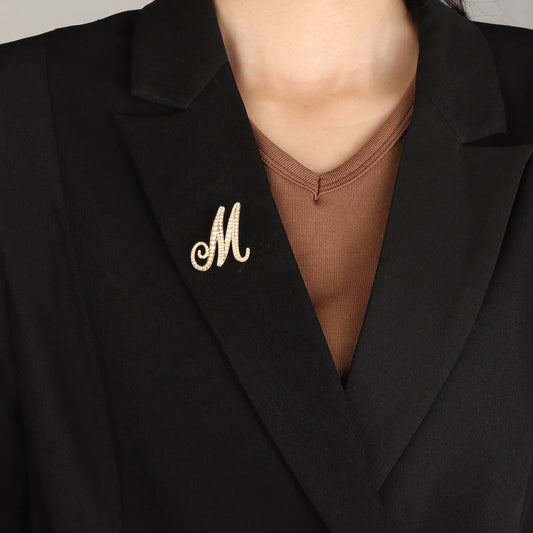 Ajatine gold pearl initial M brooch with elegant design, featuring pearls