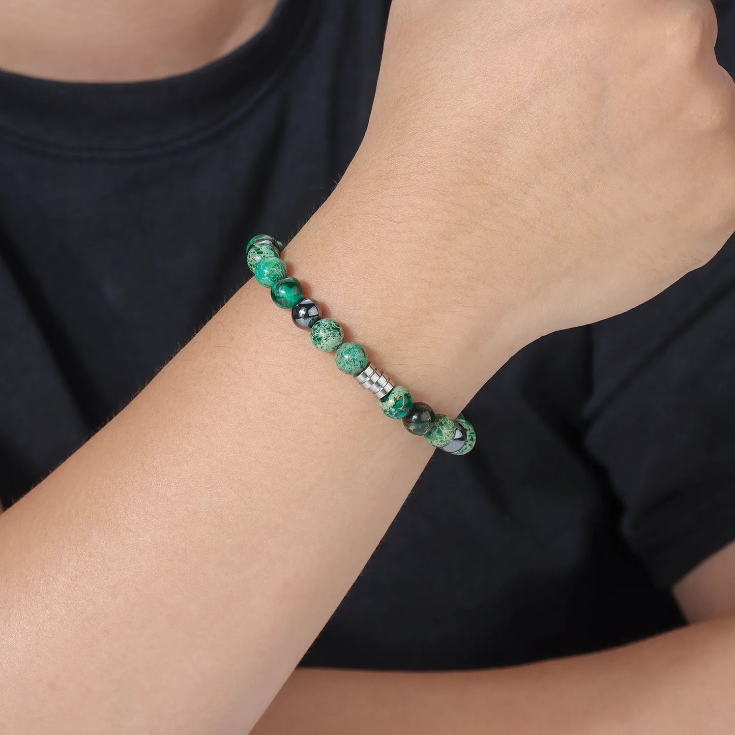 Bead bracelet with green stones and black beads, showcasing the design and details.