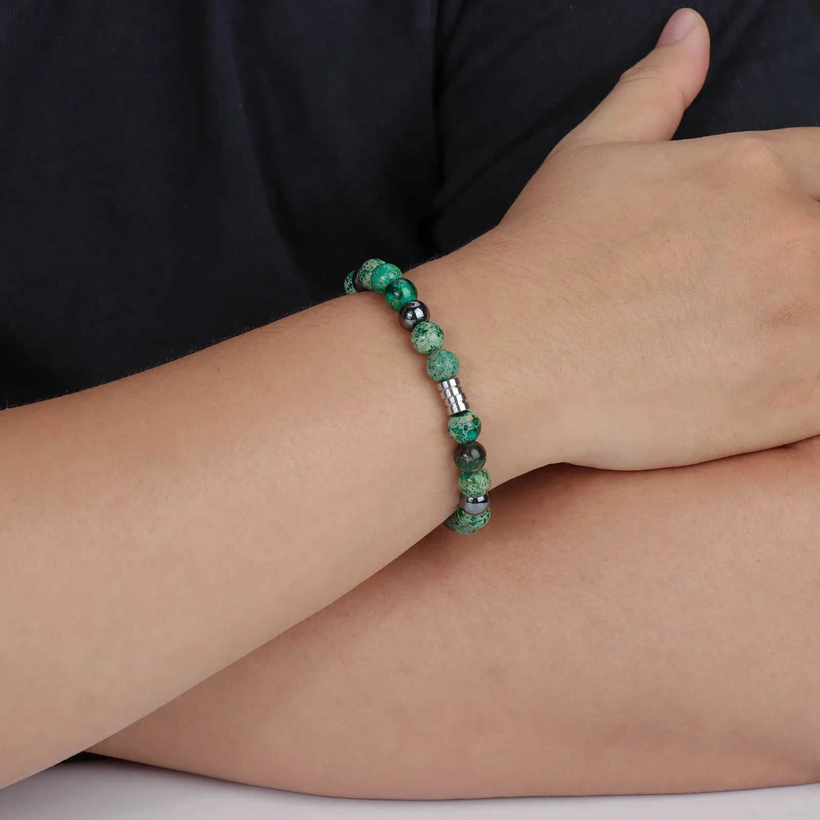 Bead bracelet with green stones and black beads, showcasing the design and details.