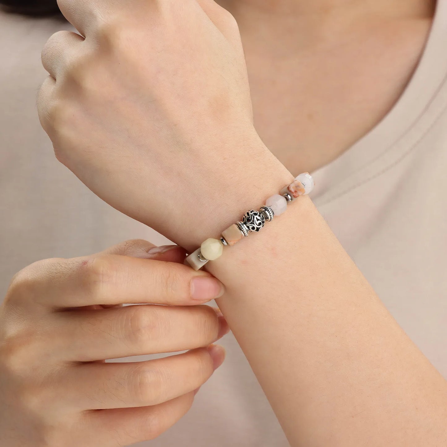A multicolored beaded bracelet with a decorative silver bead in the center.