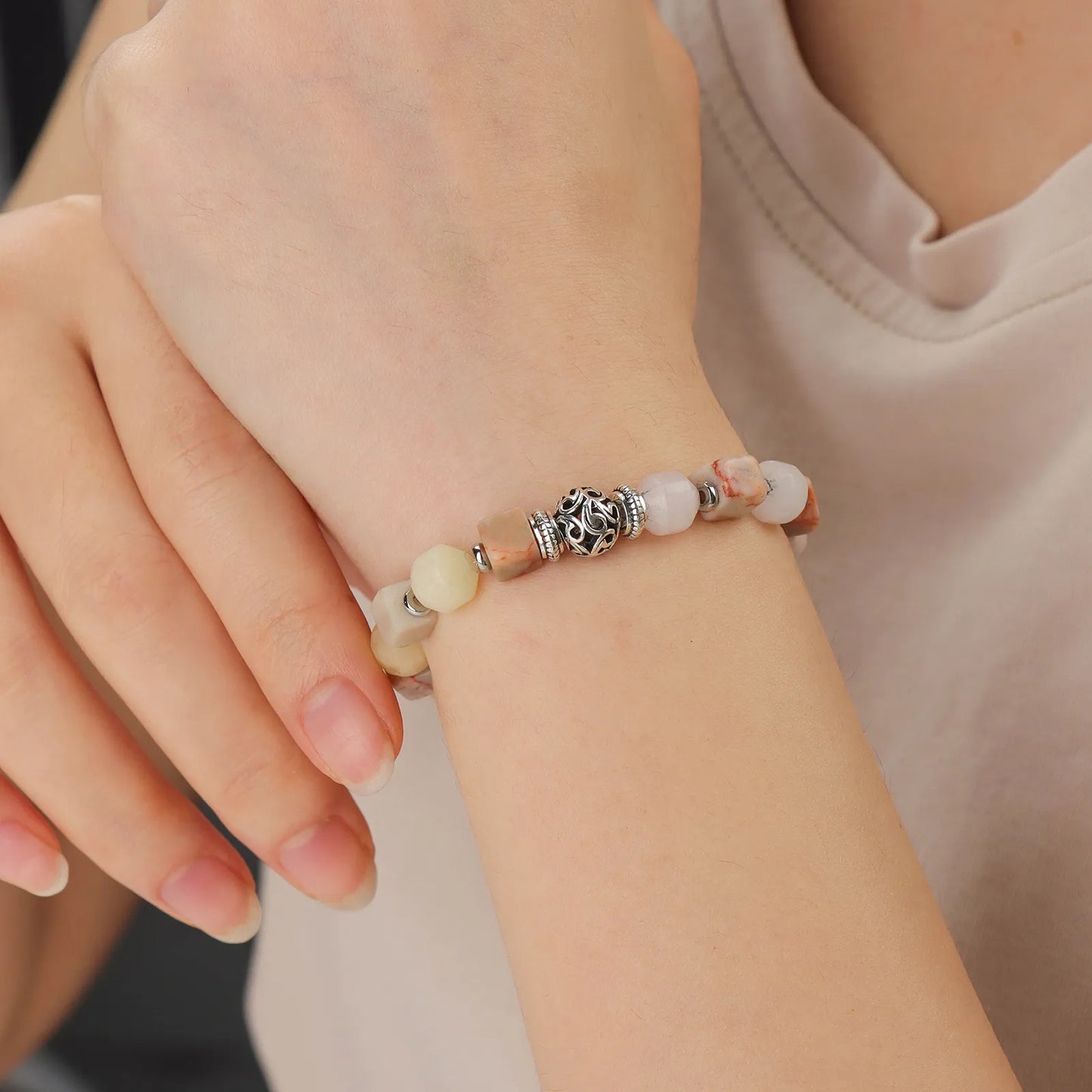A multicolored beaded bracelet with a decorative silver bead in the center.
